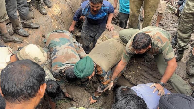 स्वयंसेवकांसह भारतीय सैन्याचे सैनिक मोडतोडातून मृतदेह पुनर्प्राप्त करतात. बचाव ऑपरेशन