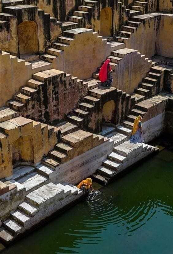 यात हे असू शकतेः पाण्याच्या मुख्य भागाच्या पुढे काही चरणांच्या काठावर दोन लोक उभे आहेत