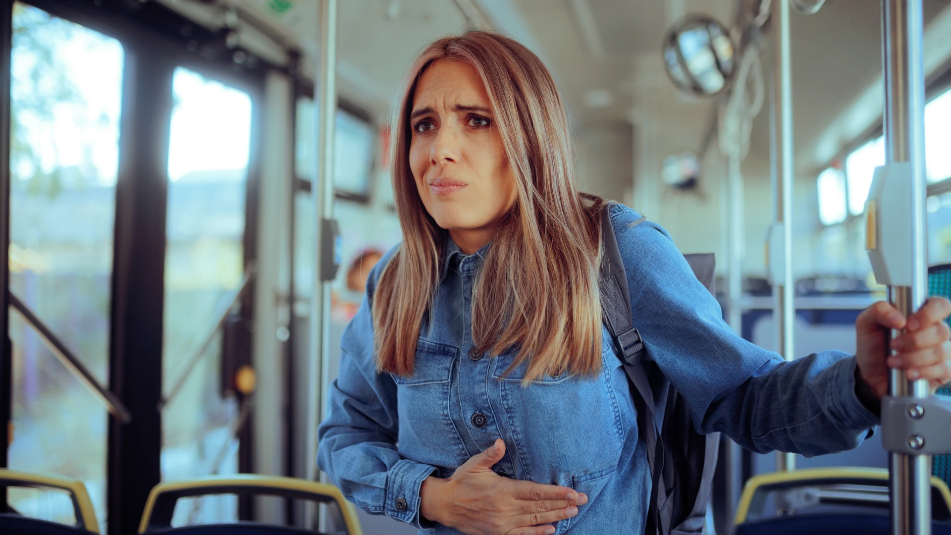 मायग्रेनचे लक्षण म्हणून मळमळ जाणवणारी स्त्री