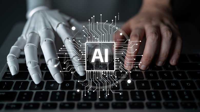 AI चिप आच्छादित केलेल्या चित्रासह, कीबोर्डवर टायपिंग करणारा मानवी आणि रोबोटिक हात