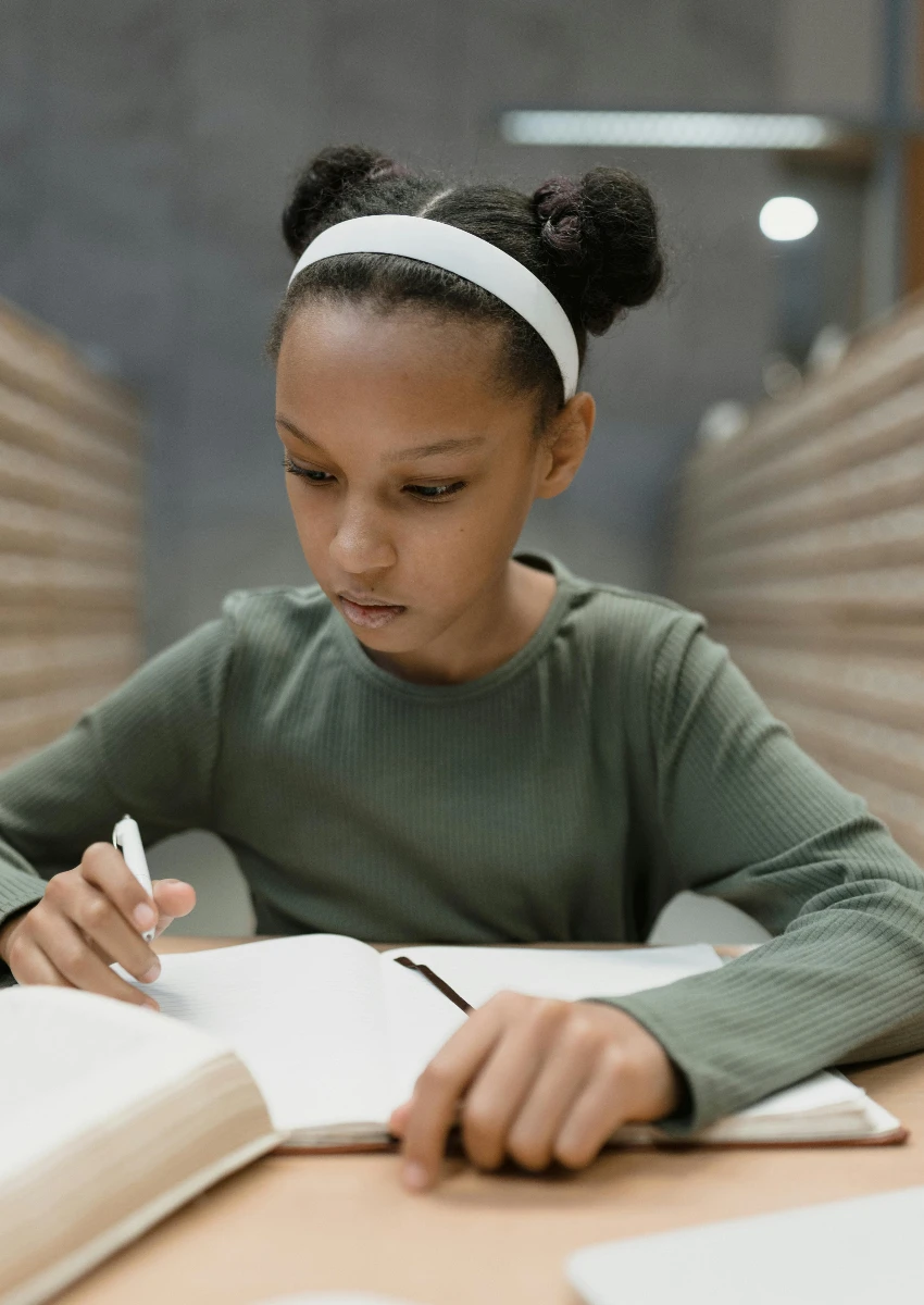 लहान मुलगी वाचते आणि अभ्यास करते