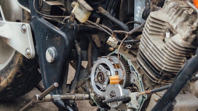 मोटरसायकल मेकॅनिक मोटरसायकल इंजिन क्लच असेंबली आणि देखभाल एकत्र करत आहेत