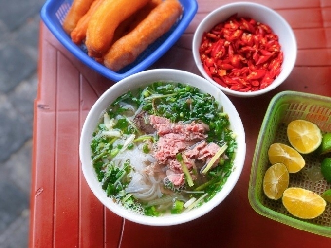 गोमांस फोचा एक वाडगा, तळलेले पीठ, लिंबूचे तुकडे आणि मिरच्या सोबत सर्व्ह केले जाते. वाचा/क्विन्ह माई द्वारे फोटो