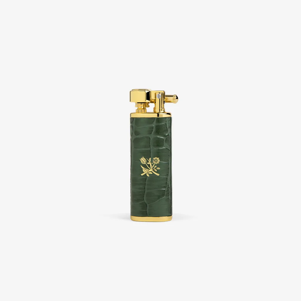 सोन्याचे टॉप आणि बेस असलेले ALD लाइटर आणि सोनेरी फुलांच्या चिन्हासह गडद हिरवा फॉक्स क्रोकोडाइल स्किन बॉडी.