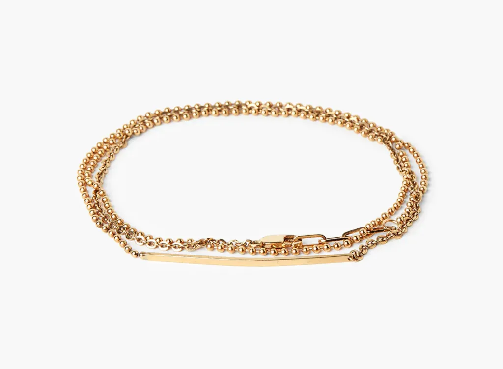 टायटल ऑफ वर्क ब्रेसलेट, लहान मणी आणि लांब, आडव्या सोन्याच्या पट्टीचा आकर्षक सोन्याचा टोन्ड चेन नेकलेस.