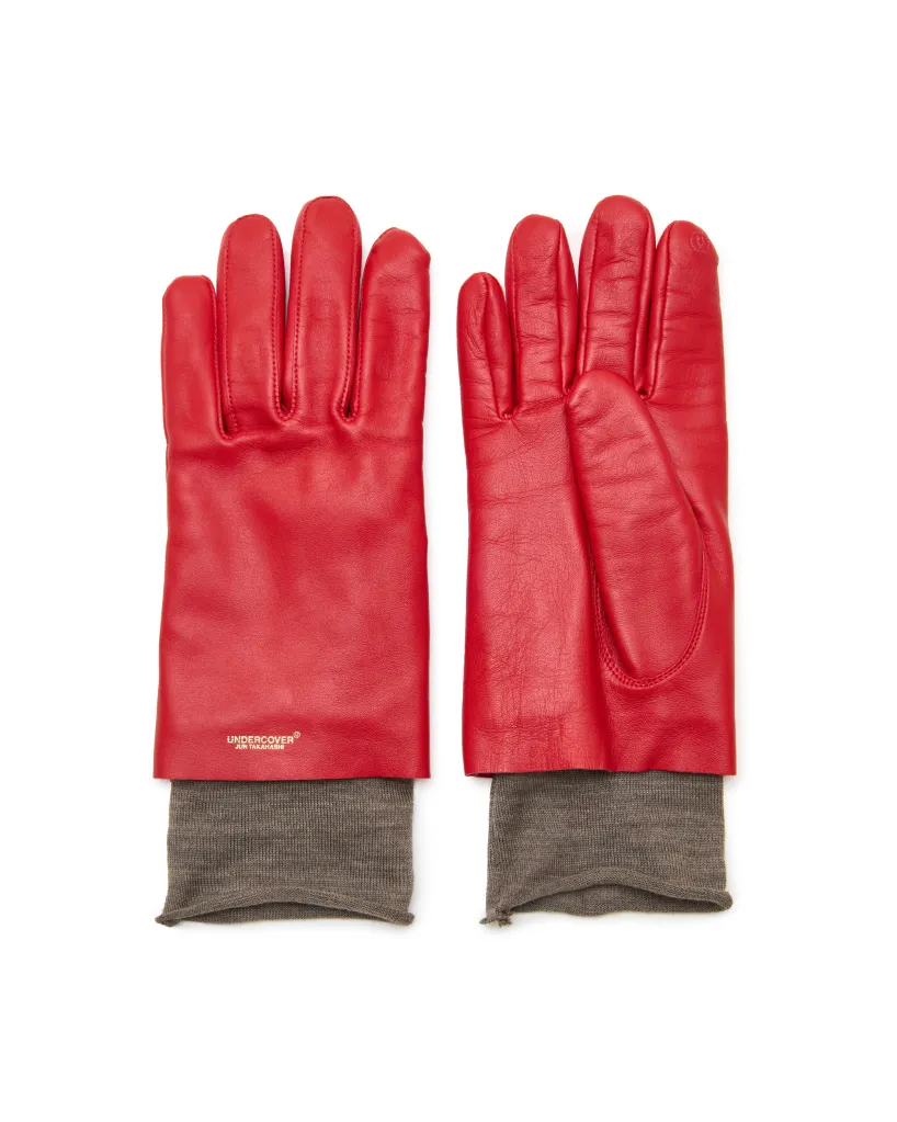 तपकिरी रिबड कफसह लाल अंडरकव्हर ग्लोव्हजची जोडी.