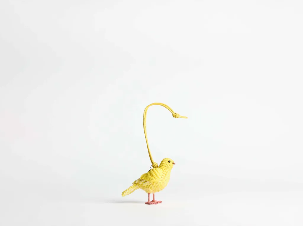 पिवळ्या चामड्याच्या पट्ट्यासह विणलेली पिवळी पक्षी पिशवी मोहिनी.