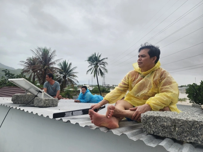 Tay Nha Trang वॉर्डातील लोक छतावर बसून बचावाची वाट पाहत होते. फोटो: बाओ होआ