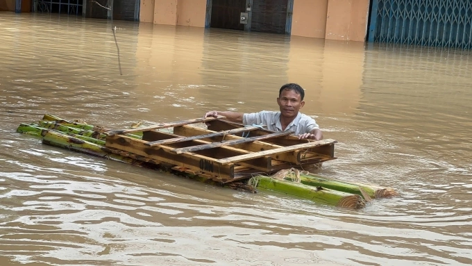 तुय होवा वॉर्डमधील रहिवासी, डाक लाक यांनी 21 नोव्हेंबर रोजी दुपारी धर्मादाय संघांकडून मदत पुरवठा घेण्यासाठी पुराच्या पाण्यातून वावरण्यासाठी केळीचा तराफा बनवला. फोटो: लुओंग विन्ह लॉन्ग नट
