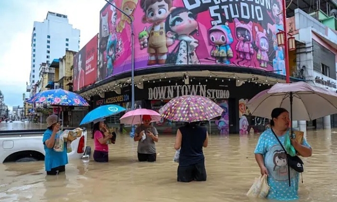 23 नोव्हेंबर 2025, थायलंडमधील हॅट याई जिल्ह्यातील पूरग्रस्त भागात लोक पाण्यात उभे आहेत. रॉयटर्सचा फोटो