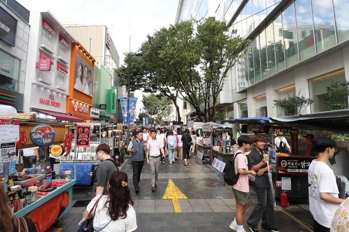 6 ऑगस्ट, 2025 रोजी दक्षिण कोरियाच्या सोलमधील म्योंगडोंग शॉपिंग क्षेत्राला पर्यटक भेट देतात. शिन्हुआने एएफपीद्वारे फोटो