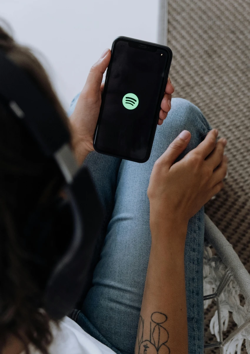त्यांच्या फोनवर Spotify ॲप उघडणारी व्यक्ती