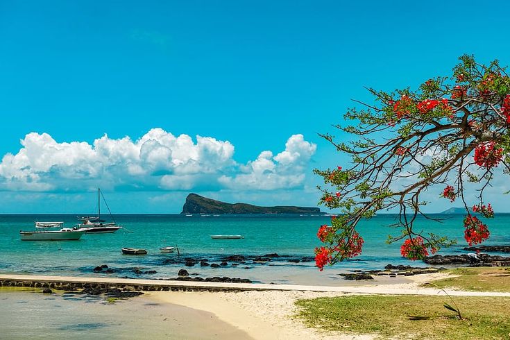 यात हे समाविष्ट असू शकते: काही खडकांजवळ बोटी पाण्यावर आहेत