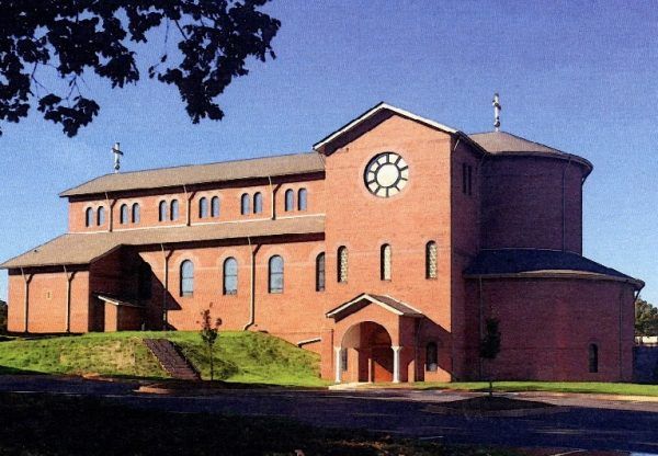 यात पुढील गोष्टींचा समावेश असू शकतो: समोर घड्याळ असलेली मोठी विटांची इमारत