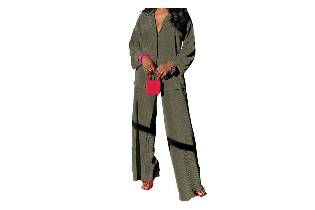 लाल सँडल आणि मिनी हँडबॅगसह ऑलिव्ह ग्रीन प्लीटेड शर्ट आणि रुंद पायातील पॅन्ट घातलेली मॉडेल.