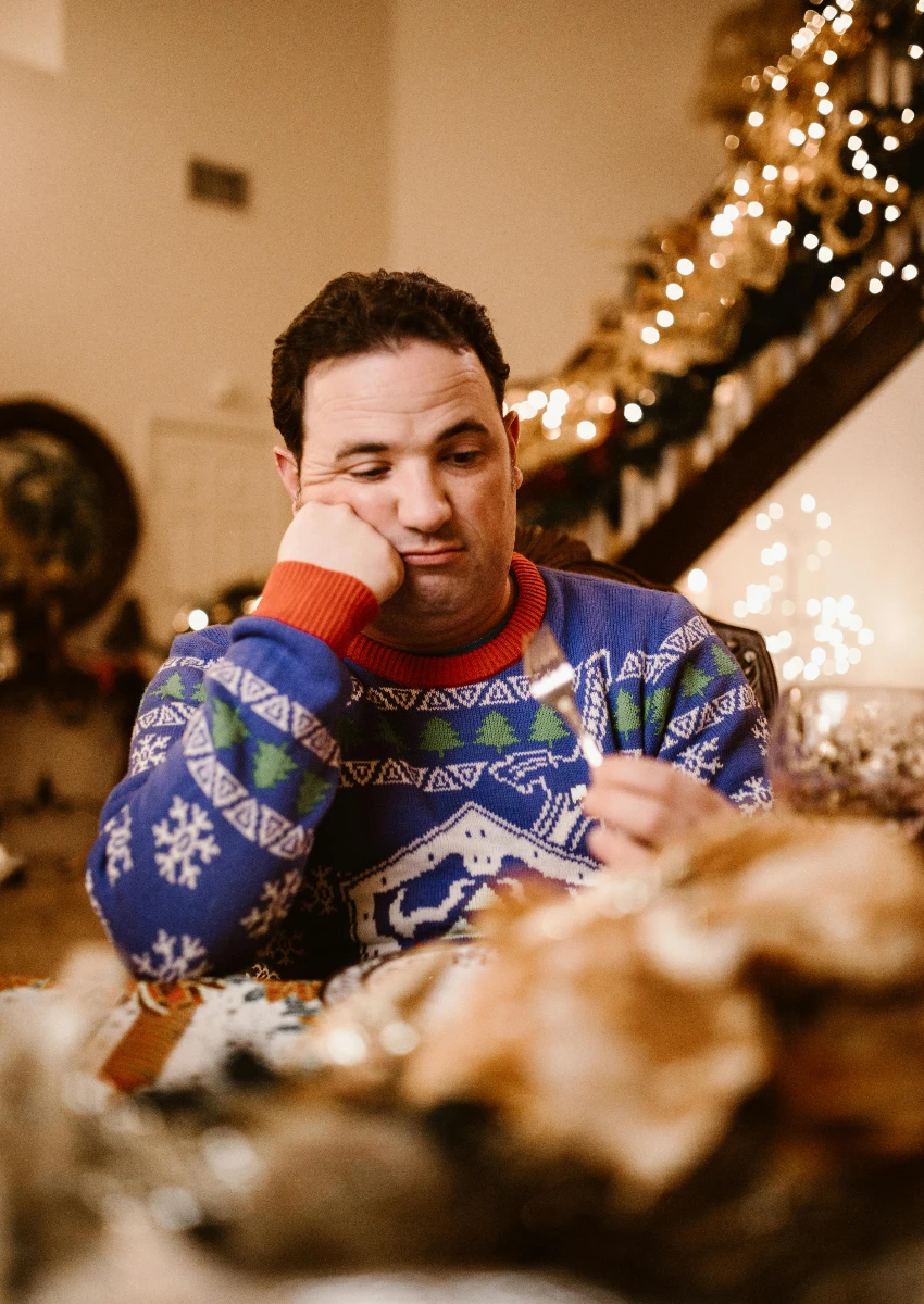 gen z माणूस त्याच्या कुटुंबासह ख्रिसमस डिनर खाताना