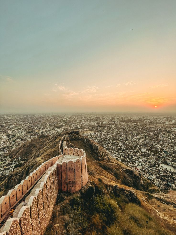 यात हे समाविष्ट असू शकते: सूर्यास्ताच्या वेळी टेकडीच्या माथ्यावरून शहर आणि त्याच्या सभोवतालच्या भिंतींचे हवाई दृश्य