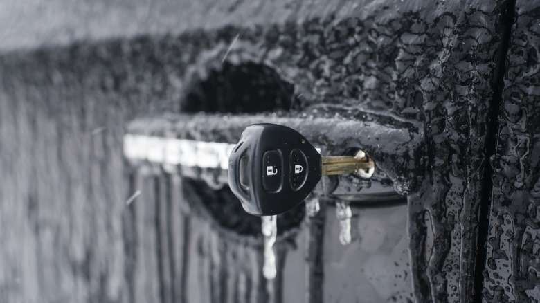 कीहोलमधील चावीसह गोठवलेला कारचा दरवाजा