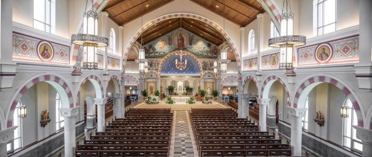 यात हे असू शकते: मोठ्या चर्चच्या आतील बाजूस दोन्ही बाजूंना पेव आणि काचेच्या खिडक्या आहेत