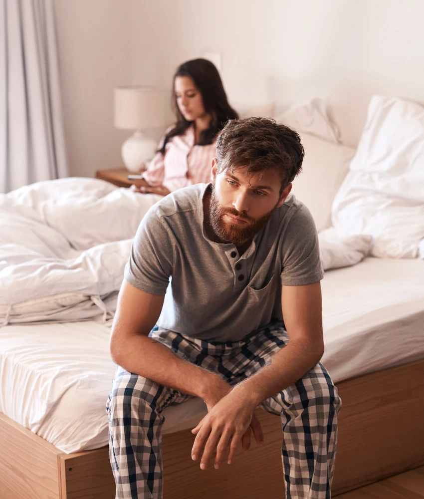 बेडरूममध्ये एकमेकांकडे दुर्लक्ष करणारे जोडपे