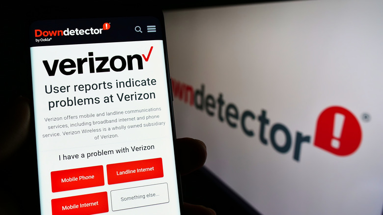 स्मार्टफोनवरील Verizon वेबसाइट डाउन डिटेक्टर वेबसाइट दर्शविणाऱ्या डिस्प्लेच्या बाजूला ठेवली आहे