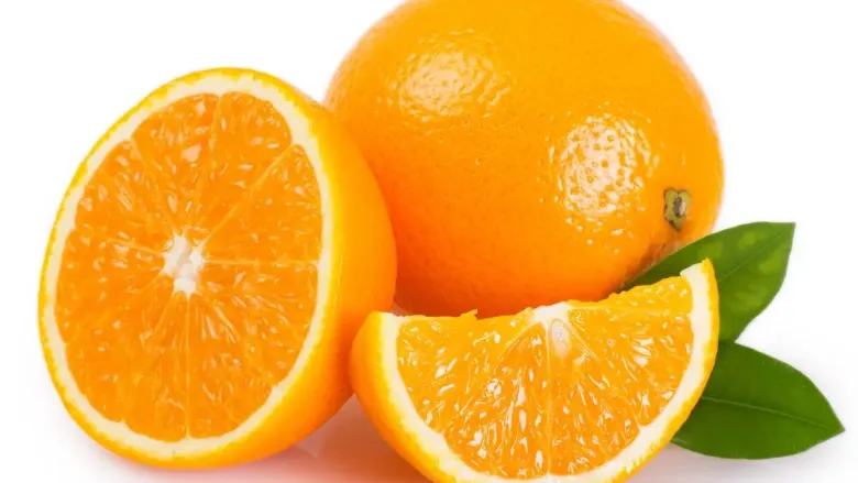 एक संपूर्ण संत्रा आणि त्याच्या बाजूला एक अर्धा तुकडा ठेवला आहे, त्यात रसाळ केशरी लगदा आणि हिरवी पाने दर्शविली आहेत.
