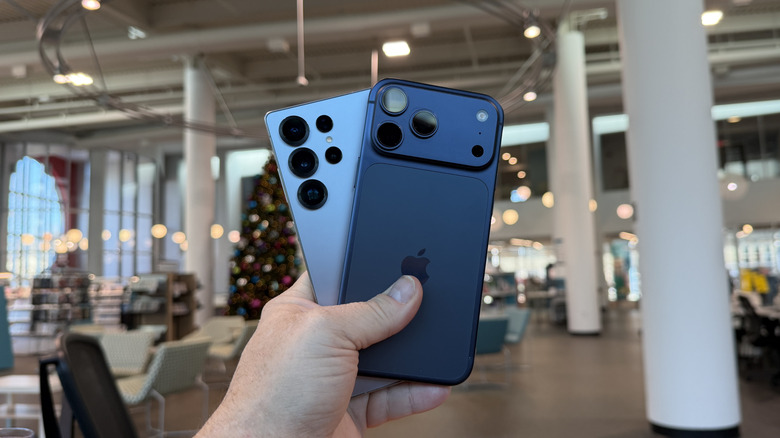 iPhone 17 Pro Max आणि Samsung Galaxy S25 Ultra हातात घेतलेला माणूस