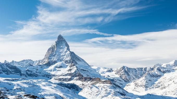 यात हे असू शकते: पर्वत बर्फाने झाकलेले आहेत आणि त्यांच्या वर ढगांसह निळे आकाश आहे