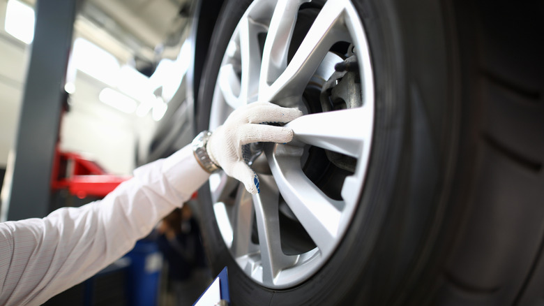 ऑटो प्रो कारच्या चाकाची तपासणी करत आहे