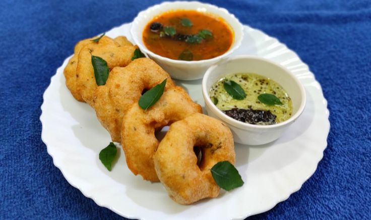 यात हे असू शकते: डिपिंग सॉससह पांढऱ्या प्लेटवर काही तळलेले अन्न