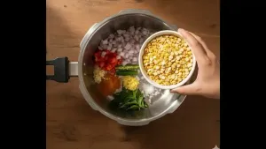 भिजवलेली मसूर निथळून प्रेशर कुकरमध्ये सोबत बारीक चिरलेला कांदा, टोमॅटो, चिरलेली हिरवी मिरची, ठेचलेला लसूण, किसलेले आले, कढीपत्ता, हळद आणि मीठ टाकावे.