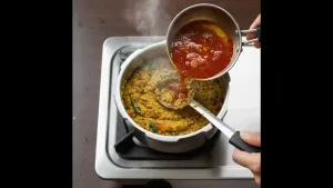 शिजलेल्या मसूरमध्ये गरम गरम ओतले आणि पूर्णपणे मिसळले. मसूर मंद आचेवर २-३ मिनिटे शिजू द्यावे.