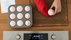 गुलाबी कपकेक रॅकवर थंड होत आहेत