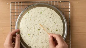 टूथपिकने ढोकळा डननेस तपासत आहे.