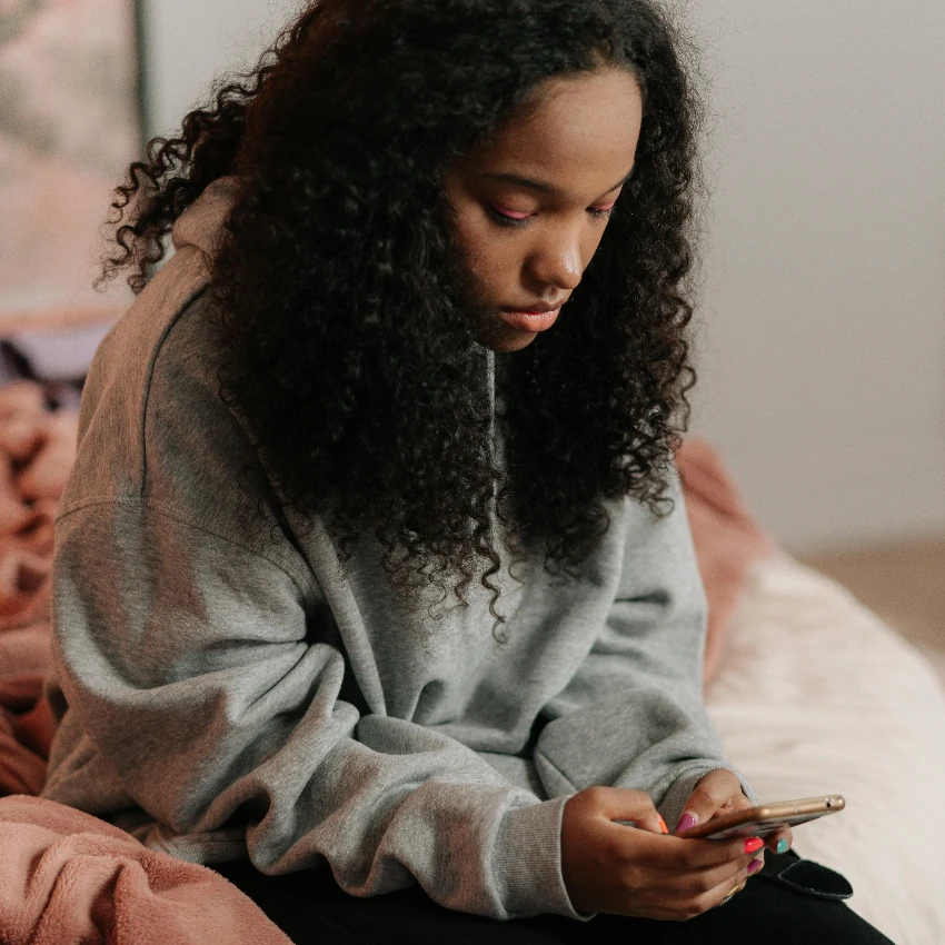 gen z स्त्री तिच्या फोनवर सामाजिकतेऐवजी