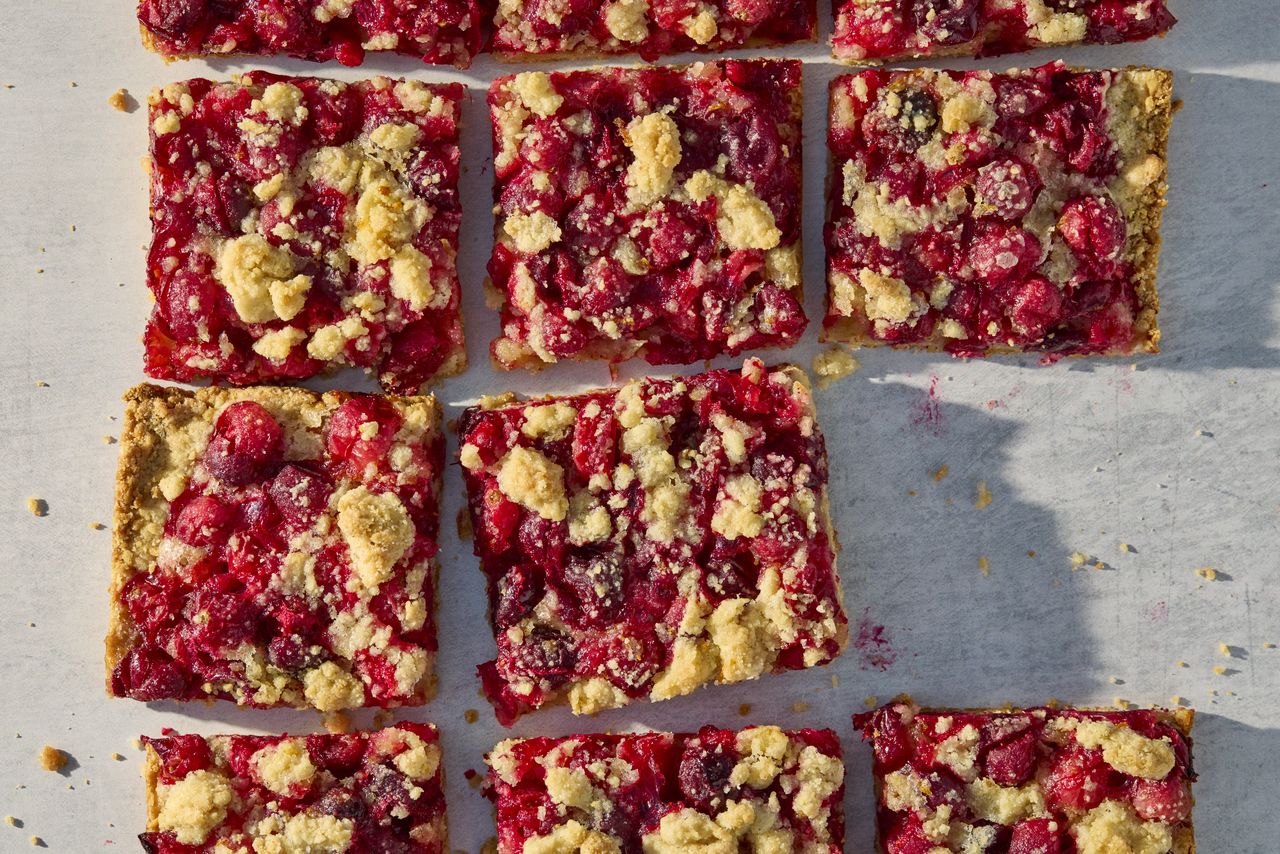 क्रॅनबेरी क्रंबल बार्सची प्रतिमा एका ग्रिडमध्ये वरून काढली आहे जेक स्टर्नक्विस्ट, फूड स्टायलिस्ट: हॉली ड्रेझमन, प्रॉप स्टायलिस्ट: नताली गजाली
