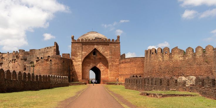 यात हे असू शकते: जुन्या विटांच्या वाड्याचे प्रवेशद्वार, त्याच्या बाजूने पायवाट आहे