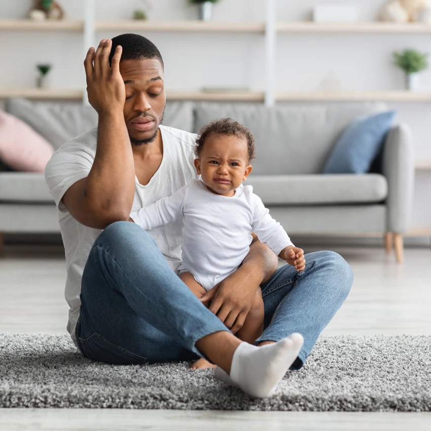 झोपेपासून वंचित असलेले वडील बाळाची काळजी घेण्यासाठी धडपडत आहेत