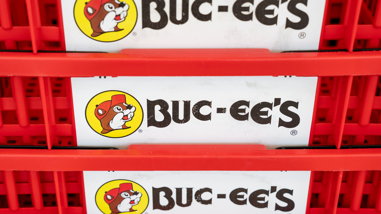 अनेक स्टॅक केलेल्या शॉपिंग बास्केटवर Buc-ee the Beaver लोगोचे क्लोज-अप