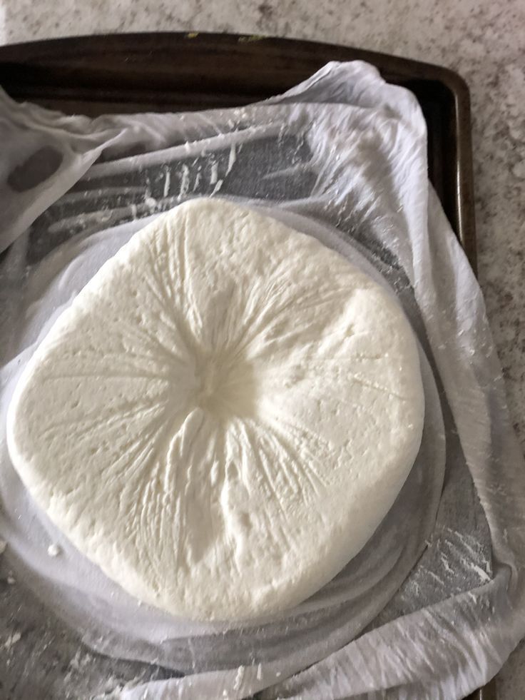 यात हे असू शकते: पॅनच्या वर बसलेला न शिजवलेला पिझ्झा