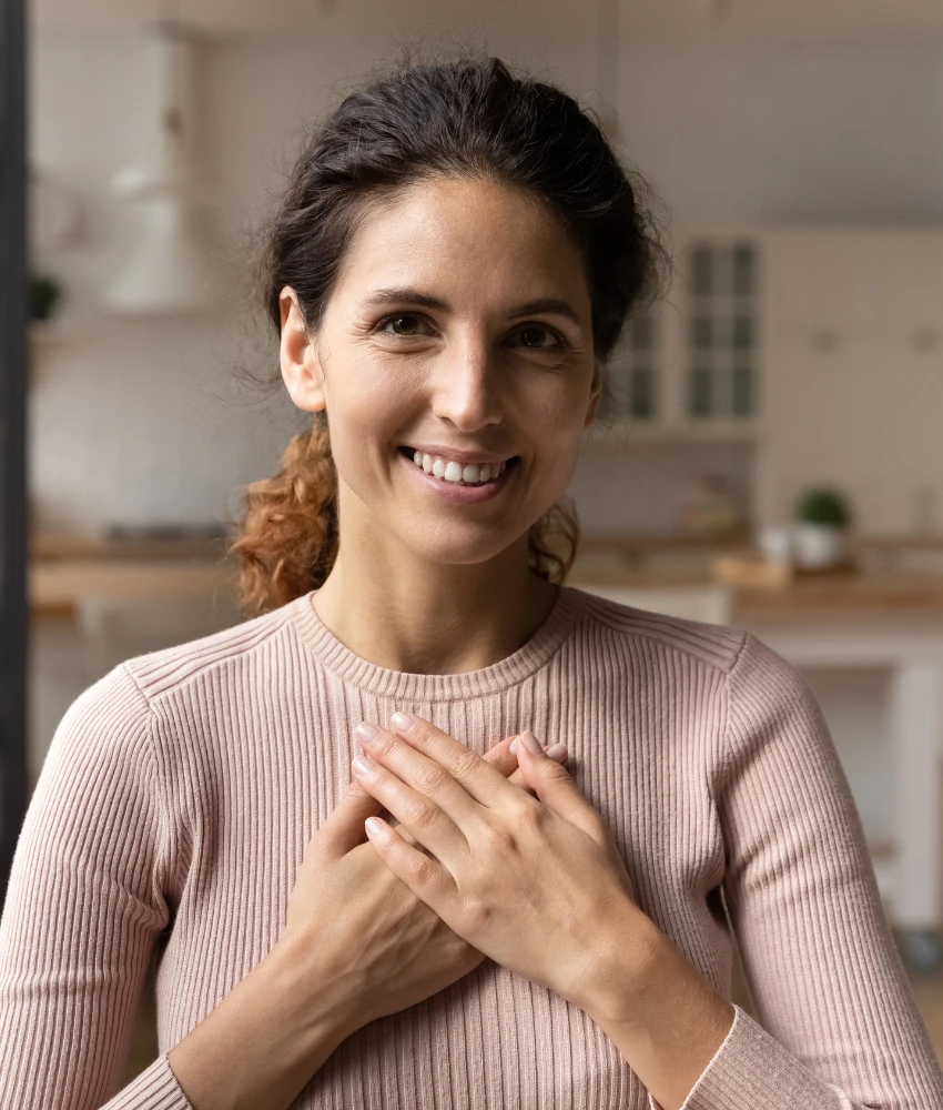 40 वर्षांची स्त्री तिच्या हृदयावर हात ठेवून