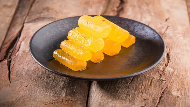 कुरकुरीत बेसन पेठाचे तुकडे साखरेच्या पाकात बुडवलेले, सर्व्हिंग डिशवर व्यवस्थित मांडलेले.