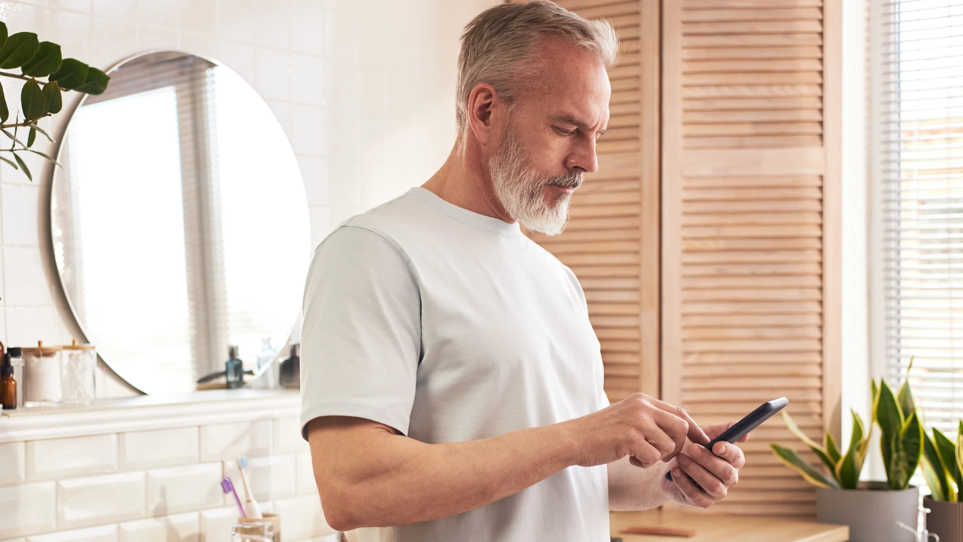 अस्वच्छ माणूस बाथरूममध्ये हात न धुत त्याचा फोन बघत आहे