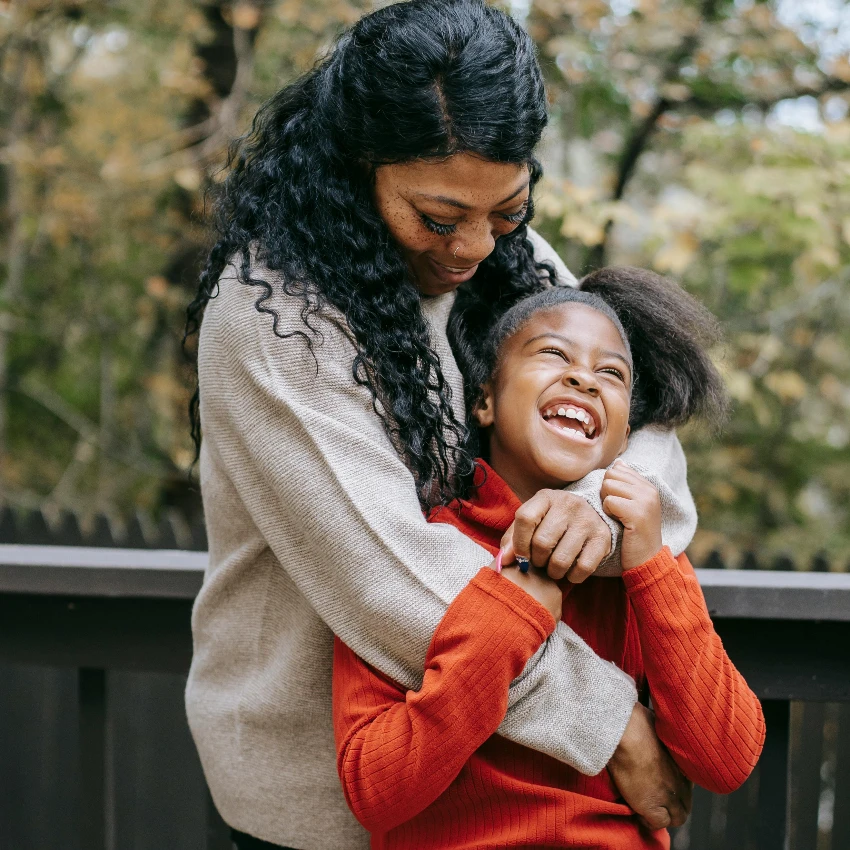 मुलगी जी आनंदी आहे कारण तिला तिच्या आईचे प्रेम वाटते