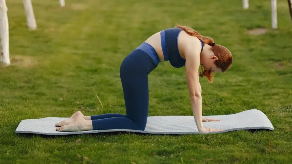 पार्कमध्ये कॅट काउ पोज देत असलेली महिला