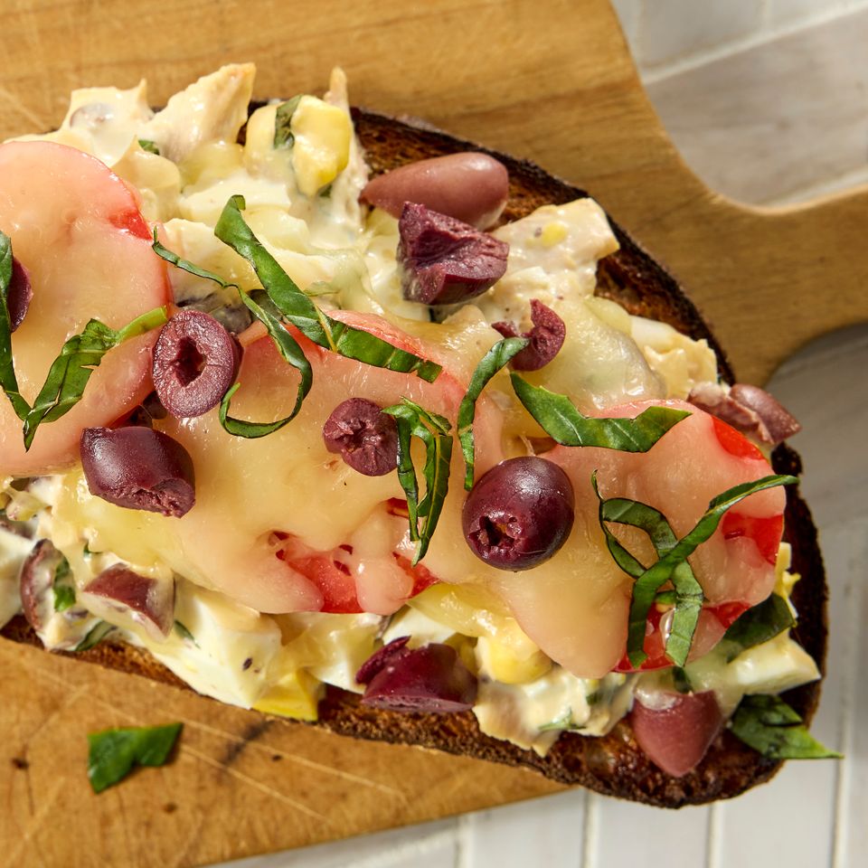 लाकडी कटिंग बोर्डवर ट्यूना मेल्टेड चीज कलामाता ऑलिव्ह हिरव्या भाज्या आणि टोमॅटोचे तुकडे असलेले ओपनफेस सँडविच क्रेडिट: छायाचित्रकार: जेन कॉसी, फूड स्टायलिस्ट: टोरी कॉक्स, प्रॉप स्टायलिस्ट: क्लेअर स्पोलेन.