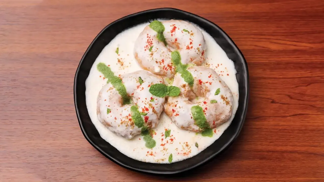 कुरळे केस आणि गडद कपडे असलेल्या व्यक्तीची विकृत आणि उलटलेली प्रतिमा, अंशतः अस्पष्ट आणि अस्पष्ट.