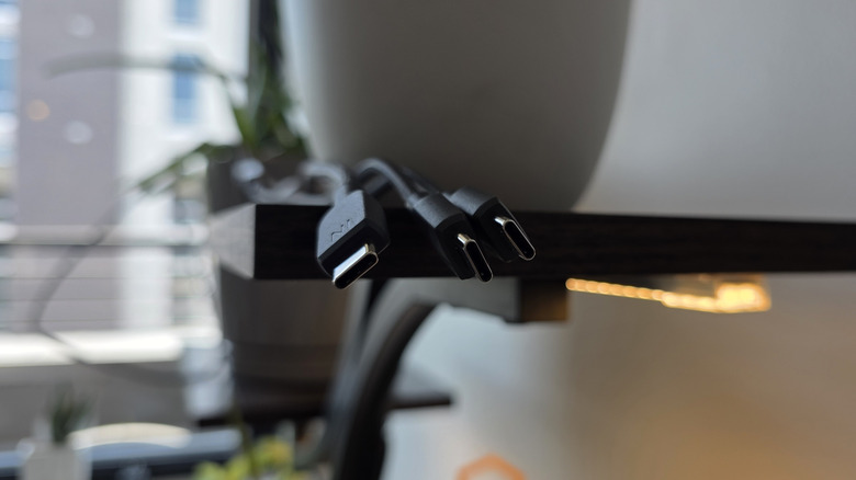 एका शेल्फमधून लटकणाऱ्या एकाधिक USB-C केबल्सचे टोक