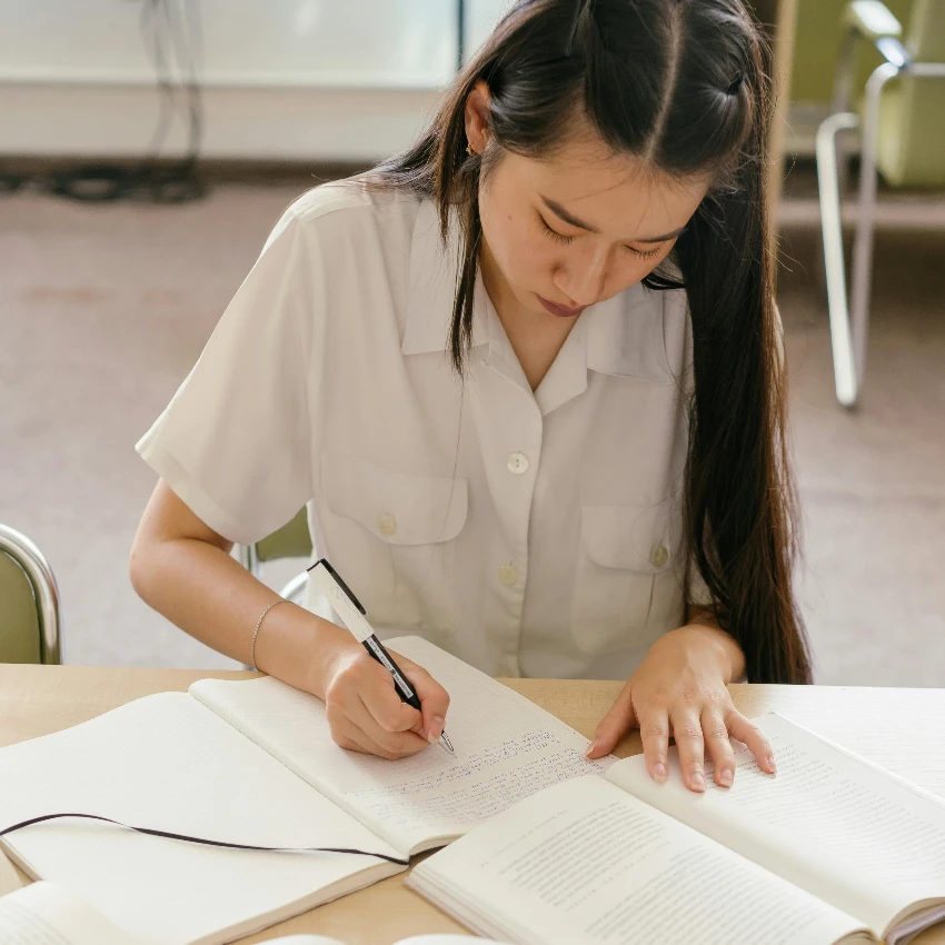 विद्यार्थी तिच्या हस्ताक्षरावर काम करत आहे