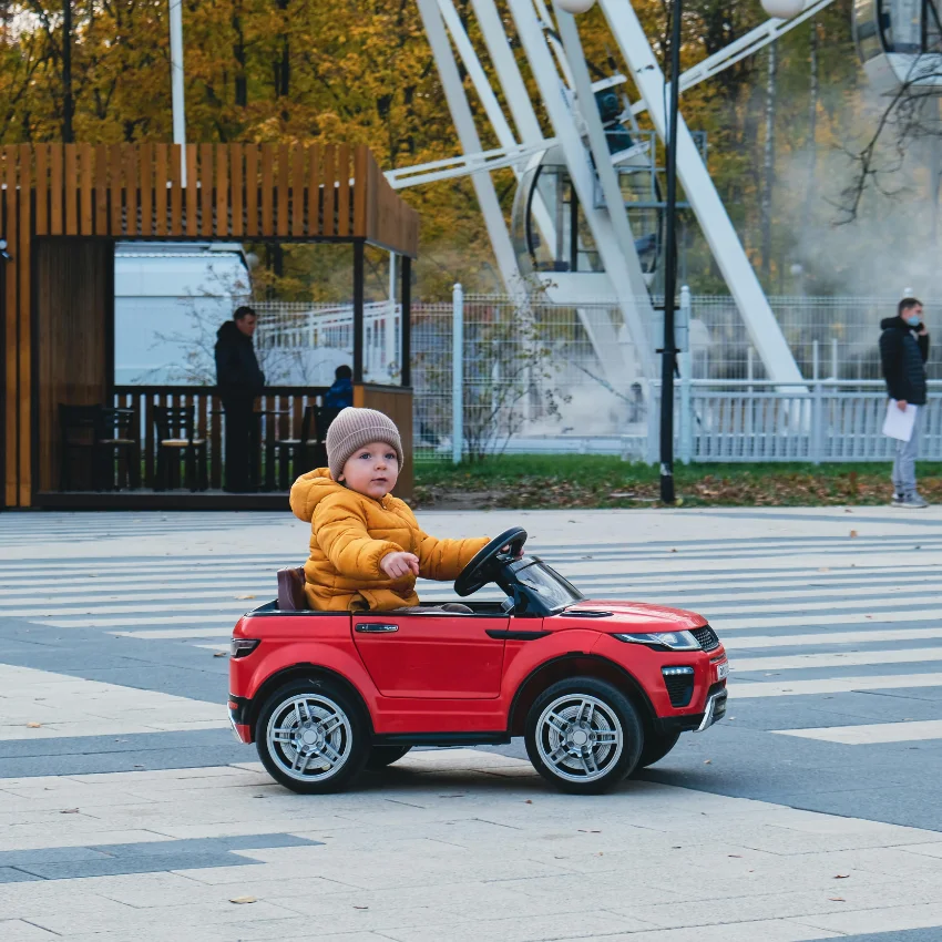 खेळण्यातील कार चालवणारे मूल